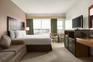 a hotel room with a bed and a flat screen tv at Travelodge by Wyndham Baie Comeau in Baie-Comeau