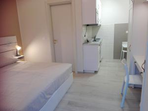 a small room with a bed and a kitchen at SMART HOME Certosa - Collegno in Collegno