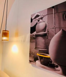 a picture on a wall with a pot and a lamp at Via Caputo 51 in Grottaglie