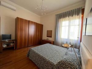 a bedroom with a bed and a tv and a window at La Casa sul Corso in Agropoli