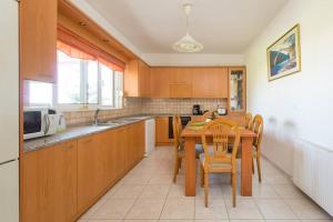 a kitchen with a table and chairs and a microwave at Garden House with sea view in Faliraki
