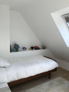 een witte slaapkamer met een bed in een kamer bij Magnifique maison de vacances à Carnac in Carnac