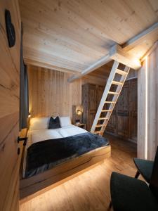 a bedroom with a bed and a staircase in a room at Chalet Silvesterhütte in Seiser Alm