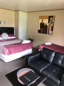 a hotel room with two beds and a couch at Aarburg Airport Motel in Christchurch