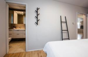a bedroom with a white bed and a bathroom at Apartments Reykjavik in Reykjavík