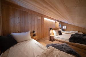 1 dormitorio con 2 camas y paredes de madera en Chalet Silvesterhütte, en Seiser Alm