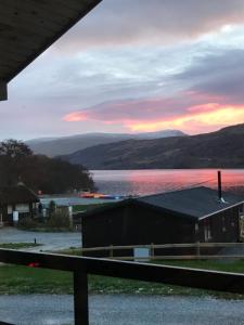 a sunset over a body of water with a building at Gulls Island in Morenish