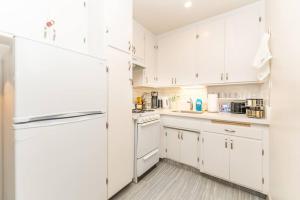 a white kitchen with white appliances and white cabinets at Seaside Romantic Escape Steps to Beach in Oceanside