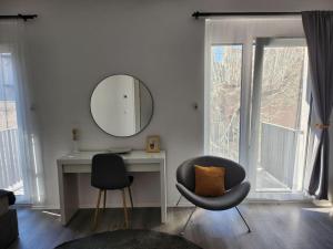 um quarto com uma secretária, 2 cadeiras e um espelho em Alice Central Apartment em Budapeste