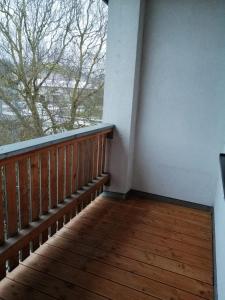 a balcony with a wooden railing and a window at Zum Feldstein in Themar