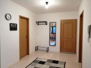 a hallway with two doors and a clock on the wall at Zum Feldstein in Themar