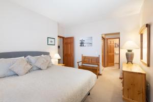 1 dormitorio con 1 cama grande y 1 silla en Deer Run by Whistler Premier, en Whistler