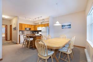 a kitchen and dining room with a wooden table and chairs at Deer Run by Whistler Premier in Whistler