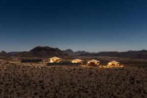 a row of tents in the desert at night at Camp Elena - Luxury Tents Minutes from Big Bend and Restaurants in Terlingua
