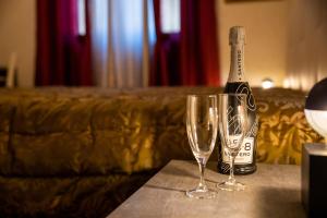 - une bouteille de champagne et deux verres sur une table dans l'établissement VATICANO BED apartment, à Bari