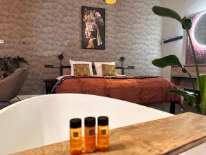 a bedroom with a bed and a bath tub at Landgoed Lodges Scholten Linde in Rossum