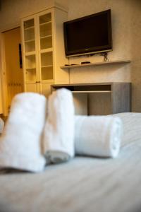 Cette chambre comprend un lit avec une télévision et des serviettes blanches. dans l'établissement VATICANO BED apartment, à Bari
