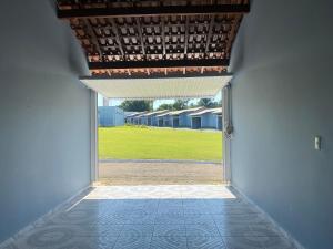 an open door with a view of a green field at HOTEL E POUSADA ISIS in São Pedro