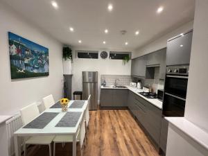 a kitchen with a table and chairs and a refrigerator at Regent Apartment - Two bedroomed Holiday Flat in Ilfracombe