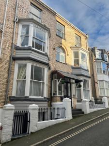 a large brick house with a fence in front of it at Regent Apartment - Two bedroomed Holiday Flat in Ilfracombe