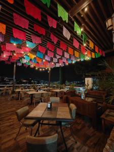 a restaurant with tables and chairs and colorful flags at Hotel 1988 Guanajuato in Guanajuato