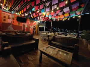 a restaurant with couches and tables and colorful flags at Hotel 1988 Guanajuato in Guanajuato