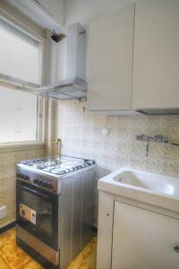 a kitchen with a stove and a sink at Ampio appartamento per 9 persone a pochi passi dal mare in Albenga