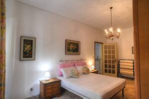 a bedroom with a bed and a chandelier at Ampio appartamento per 9 persone a pochi passi dal mare in Albenga