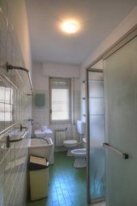 uma casa de banho com 2 WC, um lavatório e um chuveiro em Ampio appartamento per 9 persone a pochi passi dal mare em Albenga