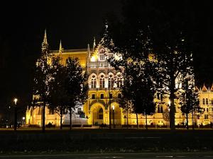 un gran edificio amarillo con luces encendidas por la noche en Lovely new apartment by the Parliament en Budapest