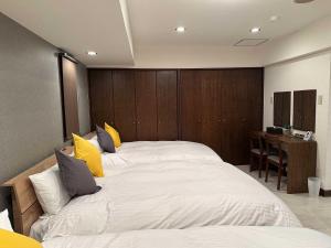 een slaapkamer met een groot wit bed met gele kussens bij LIT'S INN Sapporo - Vacation STAY 97089v in Sapporo