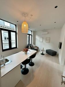 een keuken en een woonkamer met een tafel en een bank bij Appartement lumineux hyper centre in Luik