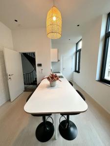 uma mesa branca com um vaso em cima numa sala em Appartement lumineux hyper centre em Liège