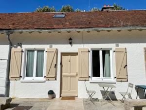 a white house with shuttered windows and a table and chairs at Le Cosy Troyen secteur calme 4 personnes parking privé in Troyes