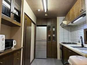 een kleine keuken met een koelkast en een wastafel bij LIT'S INN Sapporo - Vacation STAY 97105v in Sapporo
