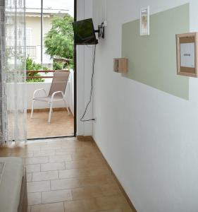 a living room with a television and a door to a patio at Ελαία Apartments in Edipsos