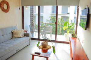 un soggiorno con divano e tavolo di Gama 09 Apartments a Tulum