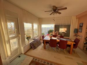 a dining room with a table and chairs and windows at Viva Bella Vista - near the Beach and AirPort in Dalaman