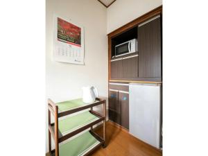 a small kitchen with a microwave and a refrigerator at Minpaku Yamamoto - Vacation STAY 13868 in Izumiotsu