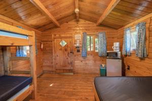 a log cabin with a kitchen and a refrigerator at Yogi Bear's Jellystone Park Camp-Resort Wisconsin Dells in Wisconsin Dells