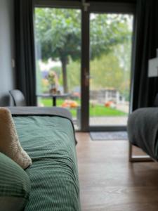 a couch in a living room with a sliding glass door at Be-B in Wageningen