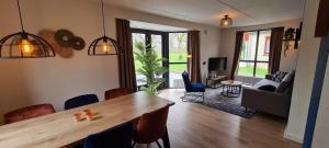 una sala de estar con una gran mesa de madera y sillas en Lakeview 'Taupo' 4-6 pers by Kawatea Cottages en Ewijk
