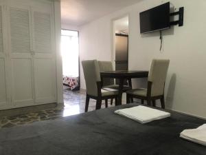 comedor con mesa, sillas y TV en Apartamento cómodo , céntrico y bien ubicado Apto 301, en Medellín