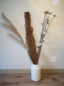 a white vase with some dried plants in it at Le splend'id disneyland in Chessy +28 photos