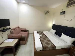 a bedroom with a bed and a couch and a table at Hotel Baba - near Charbagh Railway Station in Lucknow