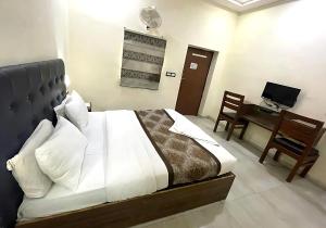 a bedroom with a bed and a desk with a computer at Hotel Baba - near Charbagh Railway Station in Lucknow