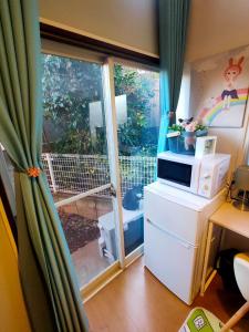 a room with a window with a microwave on a refrigerator at Glen Stage 102 - Vacation STAY 13962 in Saitama