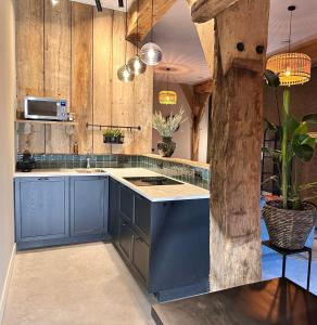 a kitchen with blue cabinets and a blue island at Landgoed Lodges Scholten Linde in Rossum