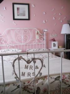 モネーリアにあるLa casa azzurraのピンクの壁に蝶が飾られたベッドルーム1室