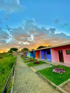 a row of colorful buildings in a field at Pousada O Canto do Jacu in Martins